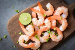 Shrimp peeled on wooden cutting board dark background dining table food, Fresh shrimps prawns seafood lemon lime with herbs and spice, top view
