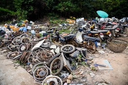 waste scrap with engine motorcycle old rust ,heap of old rusty metal wheel rims in the car drum wheel vehicle waste