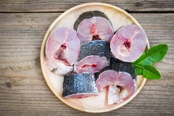Snakehead fish for cooking food, striped snakehead fish chopped with ingredients kaffir lime leaves on plate and wooden table kitchen background, Fresh raw Snake head fish menu freshwater fish