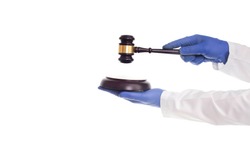 Doctor's hands hold a judicial gavel on a white background, isolate. Concept of violation of medical law, negligence of doctors