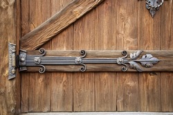 Beautiful handmade forged door hinge, close-up. Ancient architecture