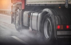 Truck chassis and wheels on a wet road in rainy weather, close-up. Safety concept and tire grip on wet roads, braking distances under emergency braking, close-up
