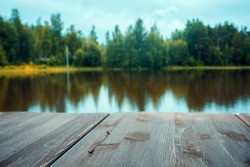 Wooden board lake with autumn  forest and lake at the background with wooden floor. can be used for display or montage your products.Mock up for display of product.
