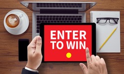 ENTER TO WIN, on the tablet pc screen held by businessman hands - online, top view