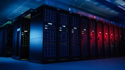 Shot of Data Center With Multiple Rows of Fully Operational Server Racks. Modern Telecommunications, Artificial Intelligence, Supercomputer Technology Concept. Shot in Dark with Neon Blue, Pink Lights
