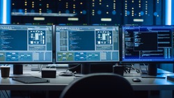 Shot of Multiple Personal Computer Monitors Showing Coding Language Program with System Monitoring Interface. In the Background Data Center with Server Racks.