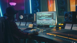 Portrait of Audio Engineer Working in Music Recording Studio, Uses Mixing Board Create Modern Sound. Successful Black Artist Musician Working at Control Desk.