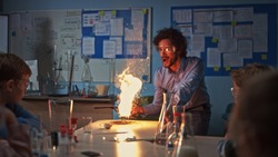 School Chemistry Classroom: Engrossed Children Watch How Enthusiastic Teacher Shows Science Experiment by Setting Powder on Fire Creating Beautiful Fireworks. Kids Getting Fun Modern Education