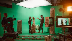 On Big Film Studio Professional Crew Shooting Period Costume Drama Movie. On Set: Director Explains Scene to Woman Actress Playing Renaissance Lady and Actor Wearing Motion Capture Suit
