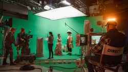 On Big Film Studio Professional Crew Shooting History Costume Drama Movie. On Set: Director Controls Cameraman Shooting Green Screen Scene with Two Actors Talented Wearing Renaissance Clothes Talking