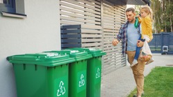 Father Holding a Young Girl and Going to Throw Away an Empty Bottle and Food Waste into the Trash. They Use Correct Garbage Bins Because This Family is Sorting Waste and Helping the Environment.