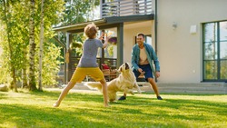 Handsome Father and Son Play Catch With Loyal Family Friend Golden Retriever Dog. Family Spending Time Together Training Dog. Sunny Day Idyllic Suburban Home Backyard.