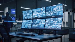 Industry 4.0 Modern Factory: Security Control Room with Multipoke Computer Screens Showing Surveillance Camera Footage Feed. High-Tech Security