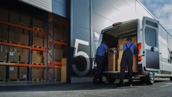 Outside of Logistics Distributions Warehouse: Two Workers Load Delivery Truck with Cardboard Boxes. Online Orders, Purchases, E-Commerce Goods.