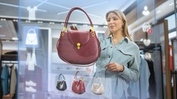 Beautiful Female Customer Using 3D Augmented Reality Digital Interface in Modern Shopping Center. Shopper is Choosing Fashionable Bags, Stylish Garments in Clothing Store. Futuristic VFX UI Concept.