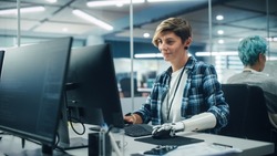 Diverse Body Positive Office: Portrait of Motivated Woman with Disability Using Prosthetic Arm to Work on Computer. Professional with Advanced Thought Controlled Body Powered Myoelectric Bionic Hand