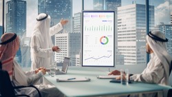 Emirati Businessman Holds Meeting Presentation for a Business Partners. Arab Manager Uses Digital Whiteboard with Growth Analysis, Charts, Statistics and Data. Saudi, Emirati, Arab Office Concept.