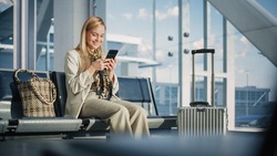 Airport Terminal: Woman Waits for Flight, Uses Smartphone, Browse Internet, Social Media, Online Shopping. Traveling Female Remote Work Online on Mobile Phone in a Boarding Lounge of Airline Hub