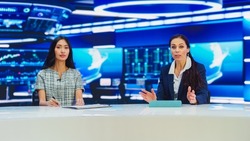 TV Live News Program: Two Presenters Reporting, Discuss Daily Events, Discuss Business, Economy, Science, Entertainment. Television Cable Channel Diverse Anchors Talk. Playback Newsroom Studio