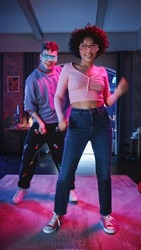 Vertical Screen: Beautiful Stylish Multiethnic Couple in Futuristic Neon Glowing Glasses, Dance and Have a Party at Home in Loft Apartment. Recording Funny Viral Videos for Social Media.