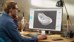 Young Male Footwear Designer Works on 3d Model of Shoe and Change Colours on It While Working on Desktop Computer in Creative Space. Shoe Production Procedure Concept.