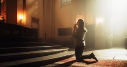 Side View: Christian Woman Getting on her Knees in Front of Altar and Starting to Pray in Church. Devoted Parishioner Seeks Guidance From Faith and Spirituality. Religious Believer in Power of God
