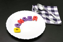 Colorful letters with word danger on plate with fork and knife, food additive and unhealthy food concept