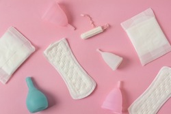 Different types of feminine menstrual hygiene materials products such as pads cloths tampons and cups. Pink background. Menstruation and feminine hygiene concept.