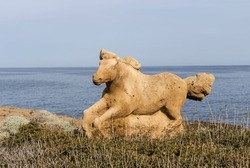 Stone sculpture of a running horse in a public park on the island of Skyros close-up (Southern sporades, Greece) against the backdrop of the sea