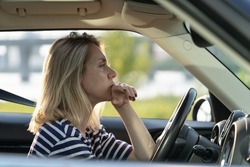 Serious anxious female driving car. Adult woman of middle age pensive sad thinking on important decision while waiting in traffic jam. Depressed or worried vehicle driver in automobile feeling bad
