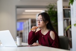 Upset thoughtful female millennial student sit at desk unable to study distracted look away pondering have issue with concentration and inspiration for writing essay in library of university campus