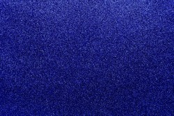 Background with sparkles. Backdrop with glitter. Shiny textured surface. Very dark blue. Soft gradient light