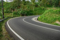 The road is winding and uphill in the Karanganyar area, Tawangmangu, Central Java. This road is next to a gas station that has not been completed yet.