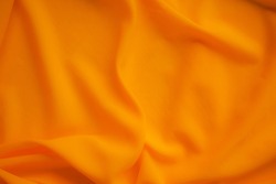 Orange Yellow color fabric patern texture cloth blur display background.light soft silk luxury smooth wave wallpaper. flat lay or top view with copy space. background for travel summer holidays.