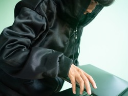 Hacker hooded steal laptop computer. hack secret password code system identity theft finance.Unauthorized access to personal data. security technology thief cyber concept.