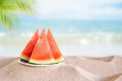 Watermelon fruits summer in plate on sand beach at coast of seaside and blue sky background.tropical fresh snack fruits for tropical tourist travel holidays. fresh orgarnic fruits .food for diet