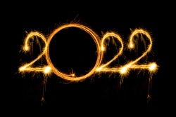 Happy new year 2022 written with sparkle fireworks on isolated black background