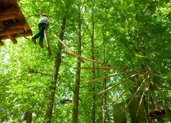 School boy climbing in adventure activity park
