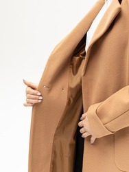 Woman in beige coat on white background. Warm coat for autumn or winter. Lined coat