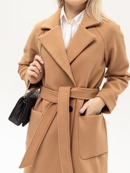 Woman in beige coat with bag on white background. Warm coat with belt. Vertical