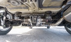 Bottom view of small car chassis and suspension. Rear suspension and differential of the vehicle all-wheel drive system. 