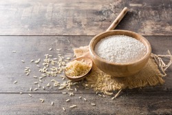 White rice flour in a bowl on wooden table. Copyspace