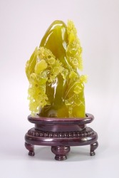 Antique Chinese nephrite jade carving isolated on grey color background. Beautiful golden color nephrite jade sculpture with birds and flowers shaped, auspicious craft
