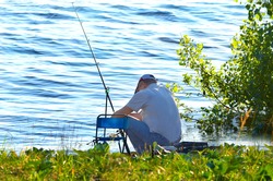 sits on a lake fisherman with a fishing rod, fishing, fishing