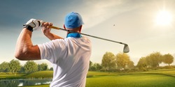 Male golf player on professional golf course. Golfer with golf club taking a shot