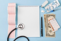 Cost of health care with USD bank notes, stethoscope, cardiogram and medicaments. Price of medicine. Medical expenses. Dollar cash money. Cost of medicinal products and treatment concept. Top view