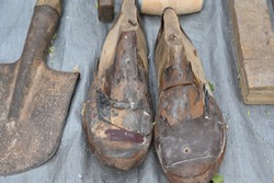Old shoe forms for handcrafted shoes on a second hand market in Spain. 
A rusty shovel lying on the ground