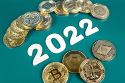 Cryptocurrency in 2022 price value prediction, forecast concept. Golden crypto coins Bitcoin, Ethereum, Tether, Nano, Chainlink and other next to the year numbers on green background.