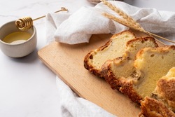 Baking and cooking. High angle view of sliced banana bread on light concrete background with honey. Delicious sweet dessert or snack, morning breakfast. Copy space