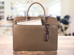 business women's bag with glasses and Notepad for writing. concept of office work or training, education on blurry background of an office space